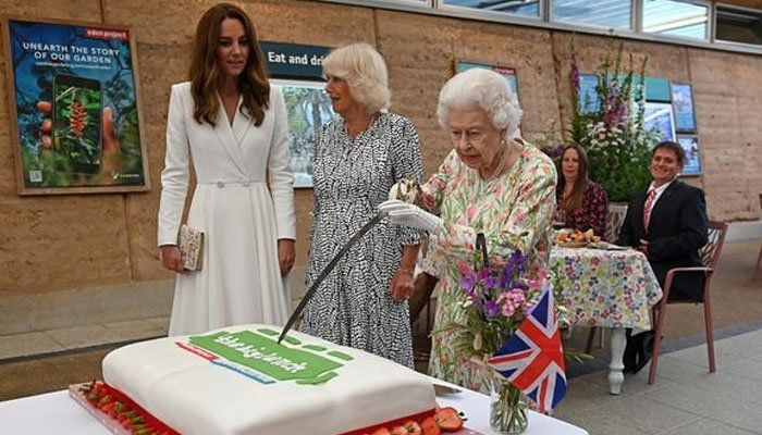 Dronning Elizabeth skjærer kake med et opp-ned seremonielt sverd