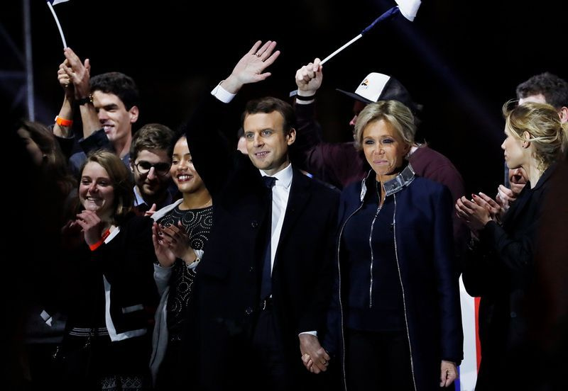 Ranskan presidentiksi valittu Emmanuel Macron (C) ja hänen vaimonsa Brigitte Trogneux (C-R) vilkuttavat yleisöä pyramidin edessä Louvren museossa Pariisissa 7. toukokuuta 2017 Ranskan presidentinvaalien toisen kierroksen jälkeen. AFP / Patrick KOVARIK