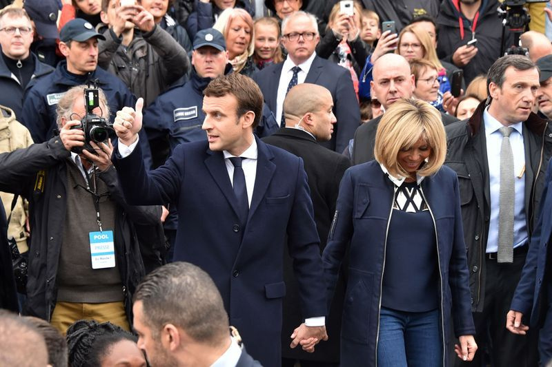 Ranskan presidentinvaalien ehdokas En Marche ! -liike Emmanuel Macron (L) pitää peukkua, kun hän ja hänen vaimonsa Brigitte Trogneux lähtivät äänestettyään Le Touquet