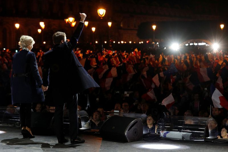 Ranskan presidentiksi valittu Emmanuel Macron (C) pitää vaimoaan Brigitte Trogneux