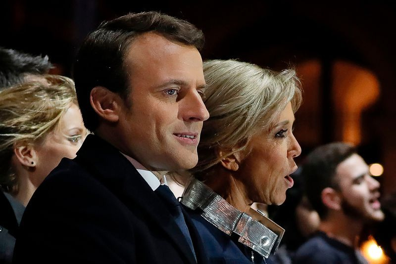 Ranskan presidentiksi valittu Emmanuel Macron (C) ja hänen vaimonsa Brigitte Trogneux (R) laulavat kansallislaulua, kun hän piti puheen Pyramidin edessä Louvre-museossa Pariisissa 7. toukokuuta 2017 Ranskan toisen kierroksen jälkeen. presidentinvaalit. AFP / POOL / THOMAS SAMSON