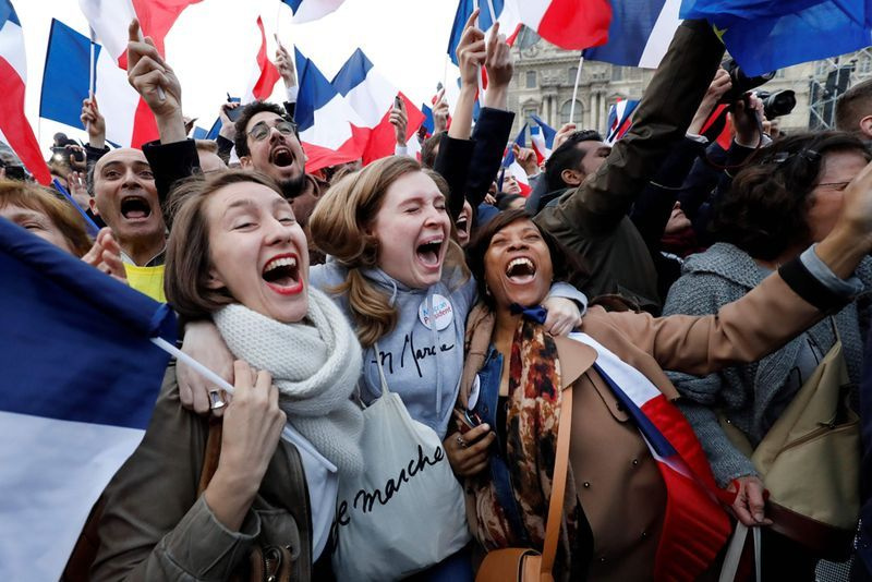 Ranskan valitun presidentin Emmanuel Macronin kannattajat reagoivat Louvre-museossa Pariisissa 7. toukokuuta 2017 Ranskan presidentinvaalien toisen kierroksen jälkeen. AFP / Patrick KOVARIK